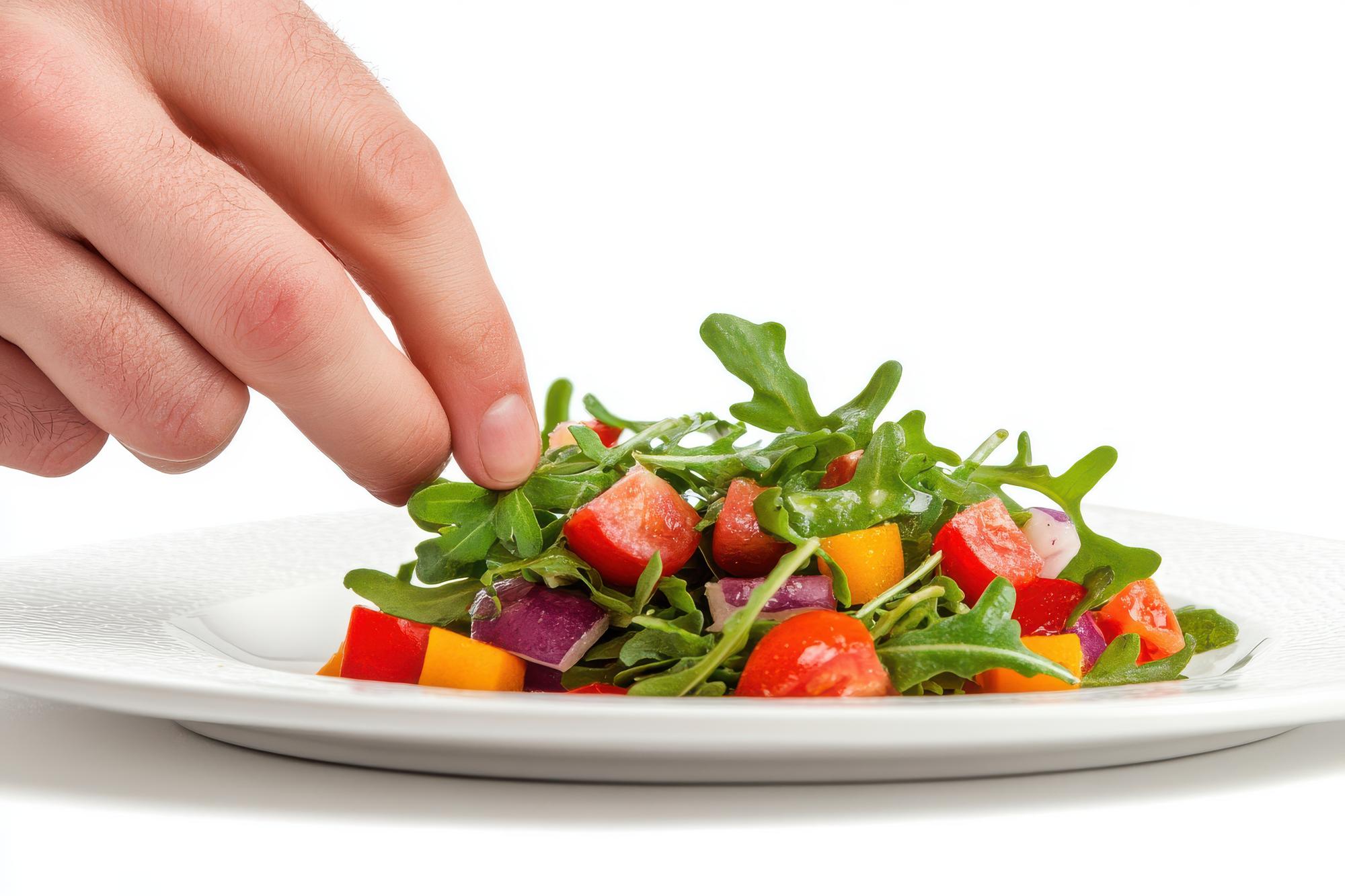 Hand plating a colorful salad